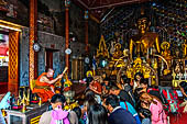 Chiang Mai - Wat Phra That Doi Suthep. Buddhist monk is blessing with lustral water visitors  inside the Northern vihan.